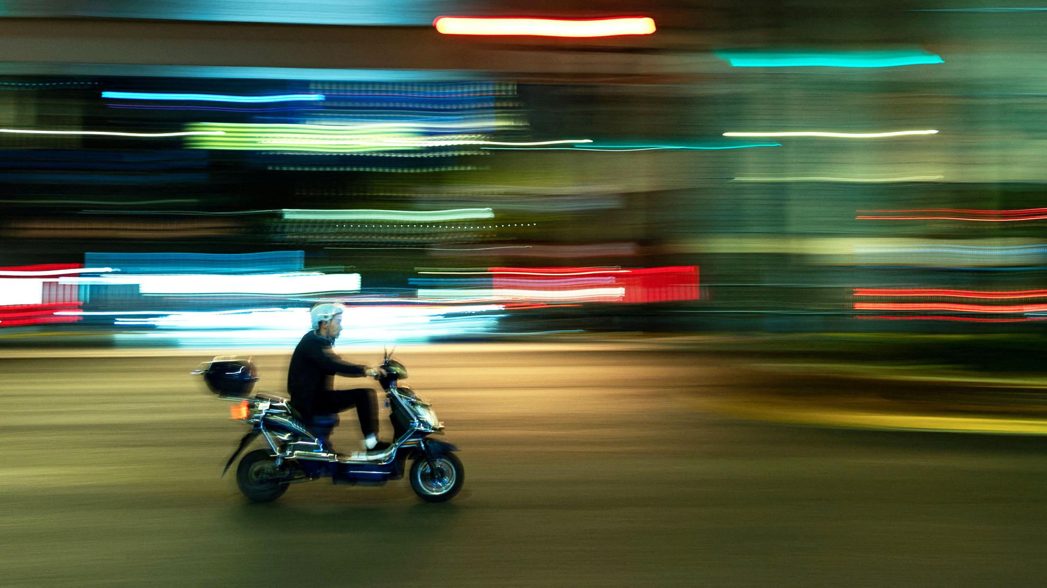 A man rides his scooter in the street in Shanghai, China. Picture taken on November 4, 2025. 