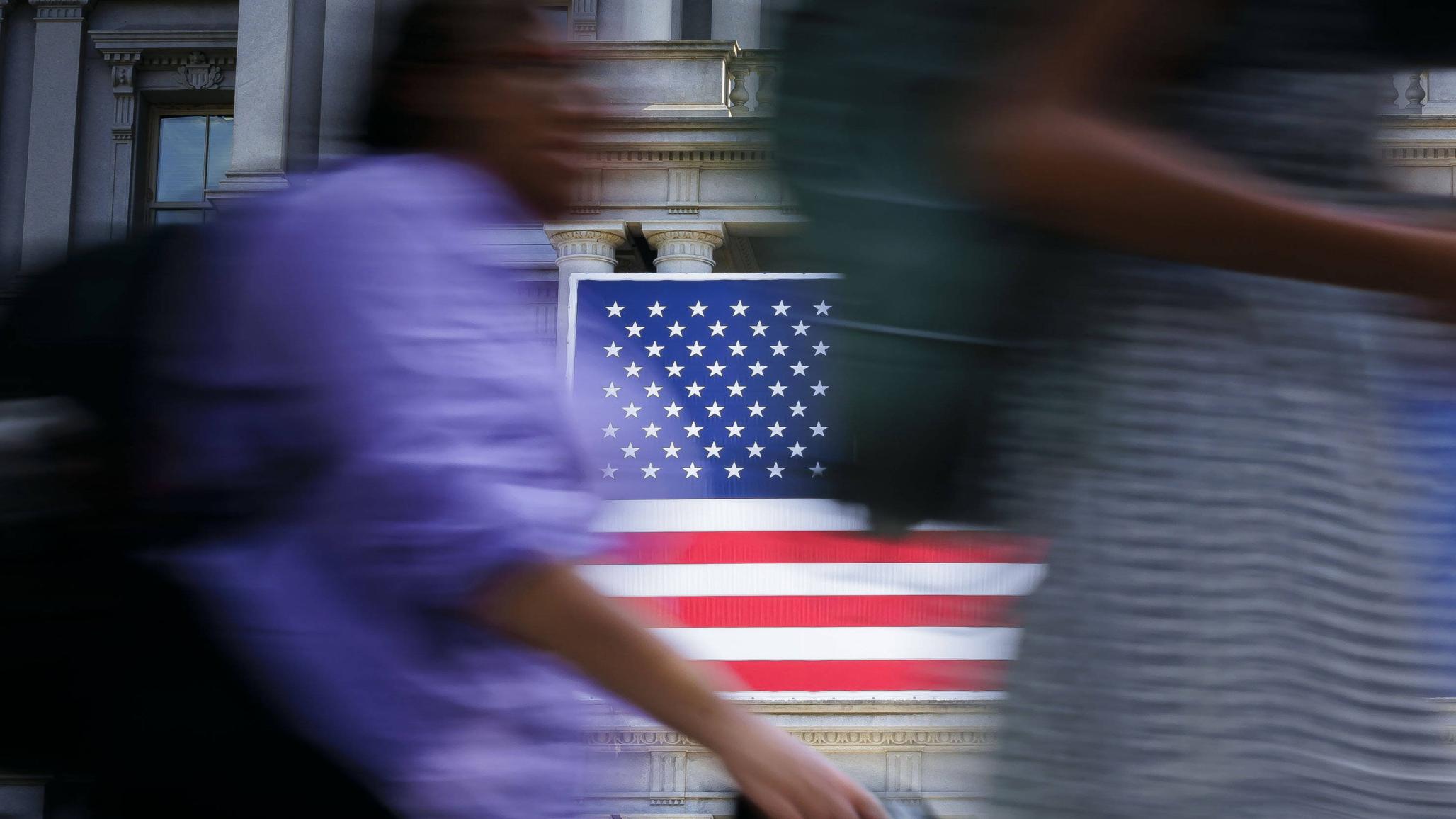 The US flag is shown hanging from a government building in Washington, DC. 