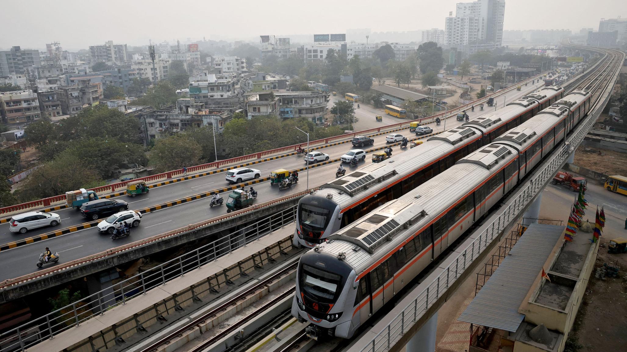 Metro trains move past commuters near the Sabarmati Metro station in Ahmedabad, India. Picture taken on January 31, 2026. 