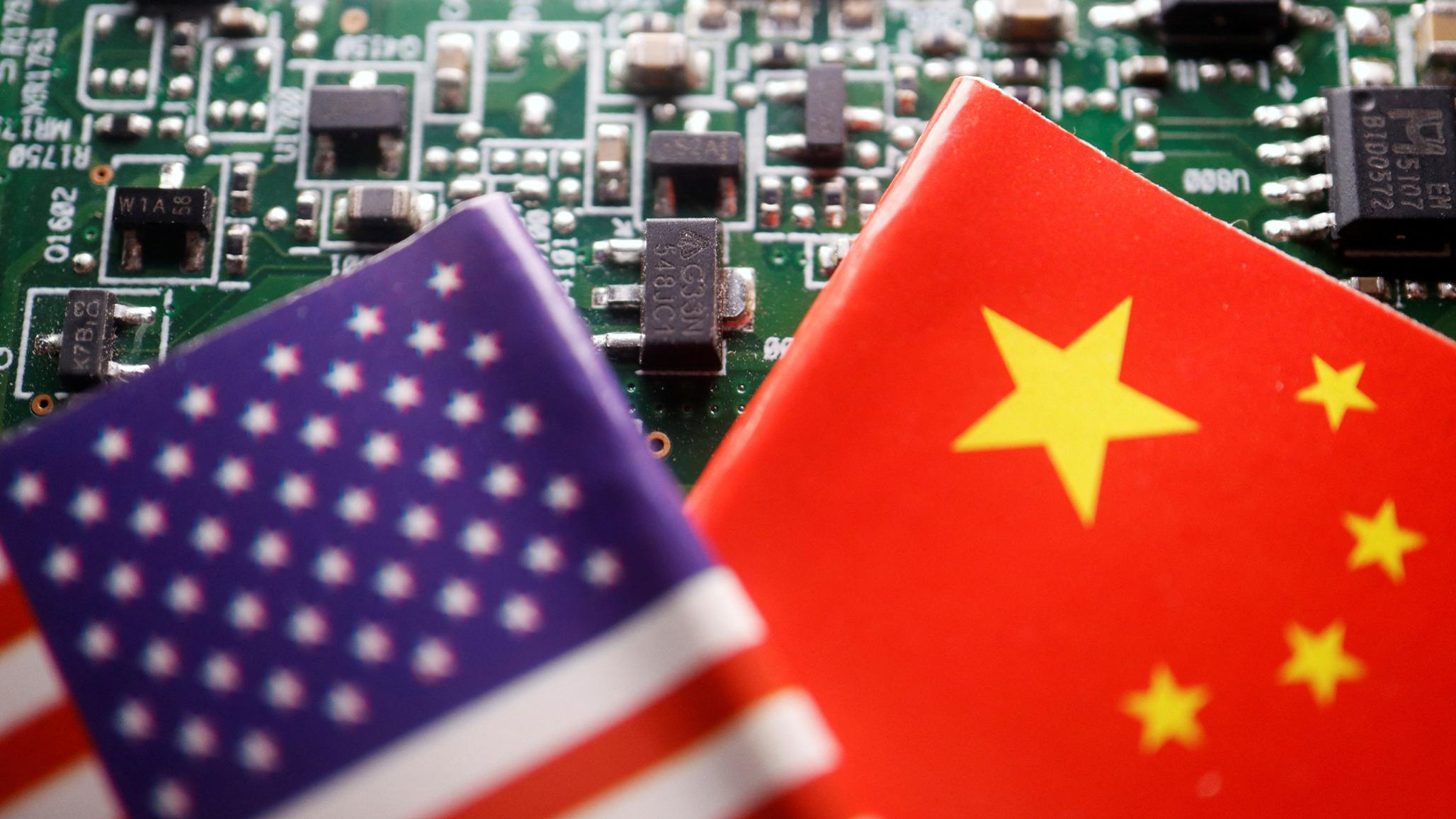 Flags of the US and China are displayed on a printed circuit board with semiconductor chips, in this illustration. 