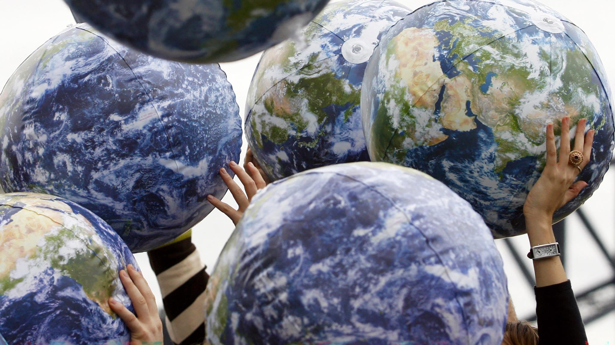 People hold up inflatable world globes during a celebration in Sydney, Australia. Photo taken on June 5, 2009. 