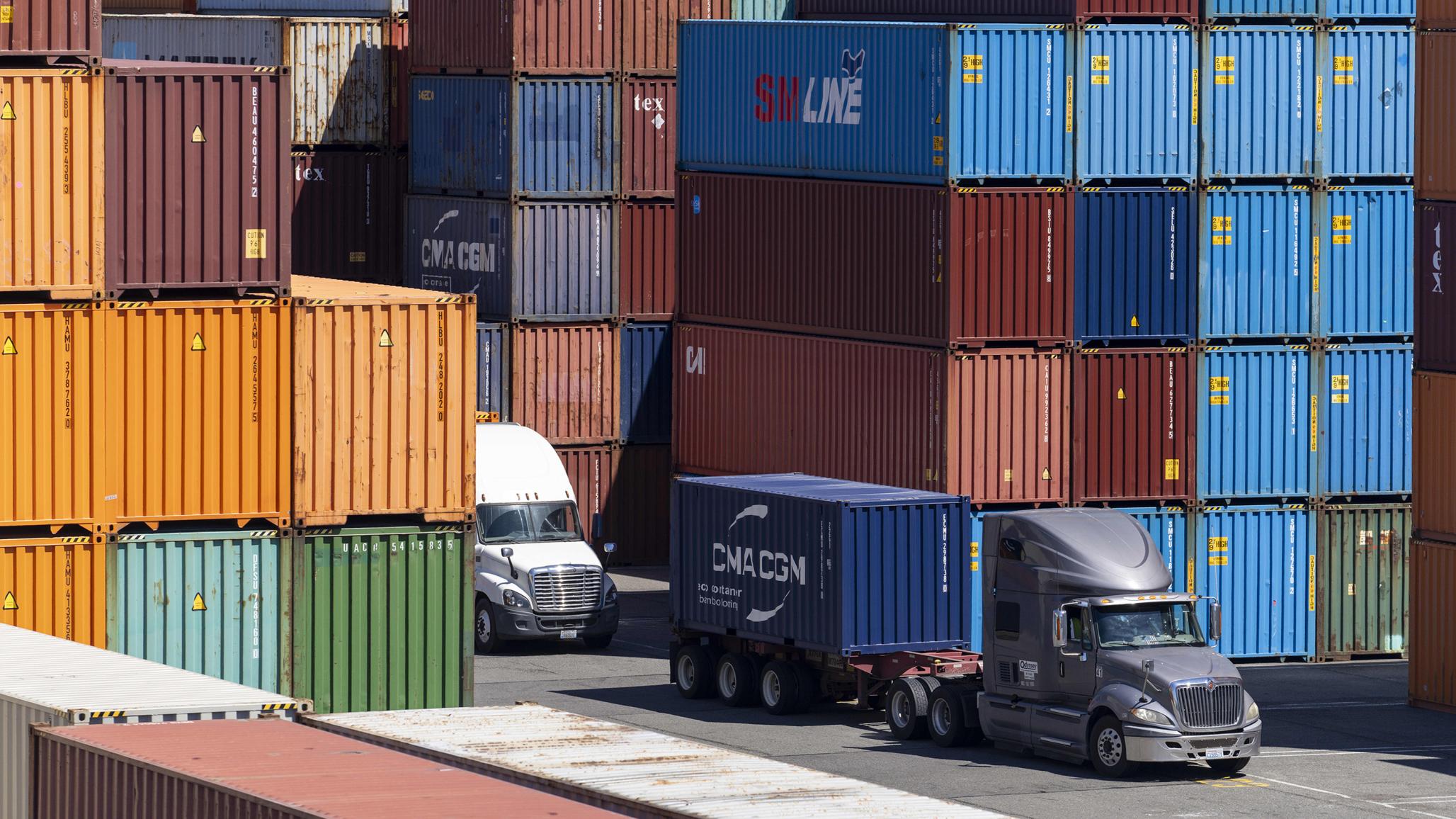 Trucks carry shipping containers to be unloaded and stacked in the Port of Seattle in Seattle, Washington. Photo taken on August 11, 2025. 