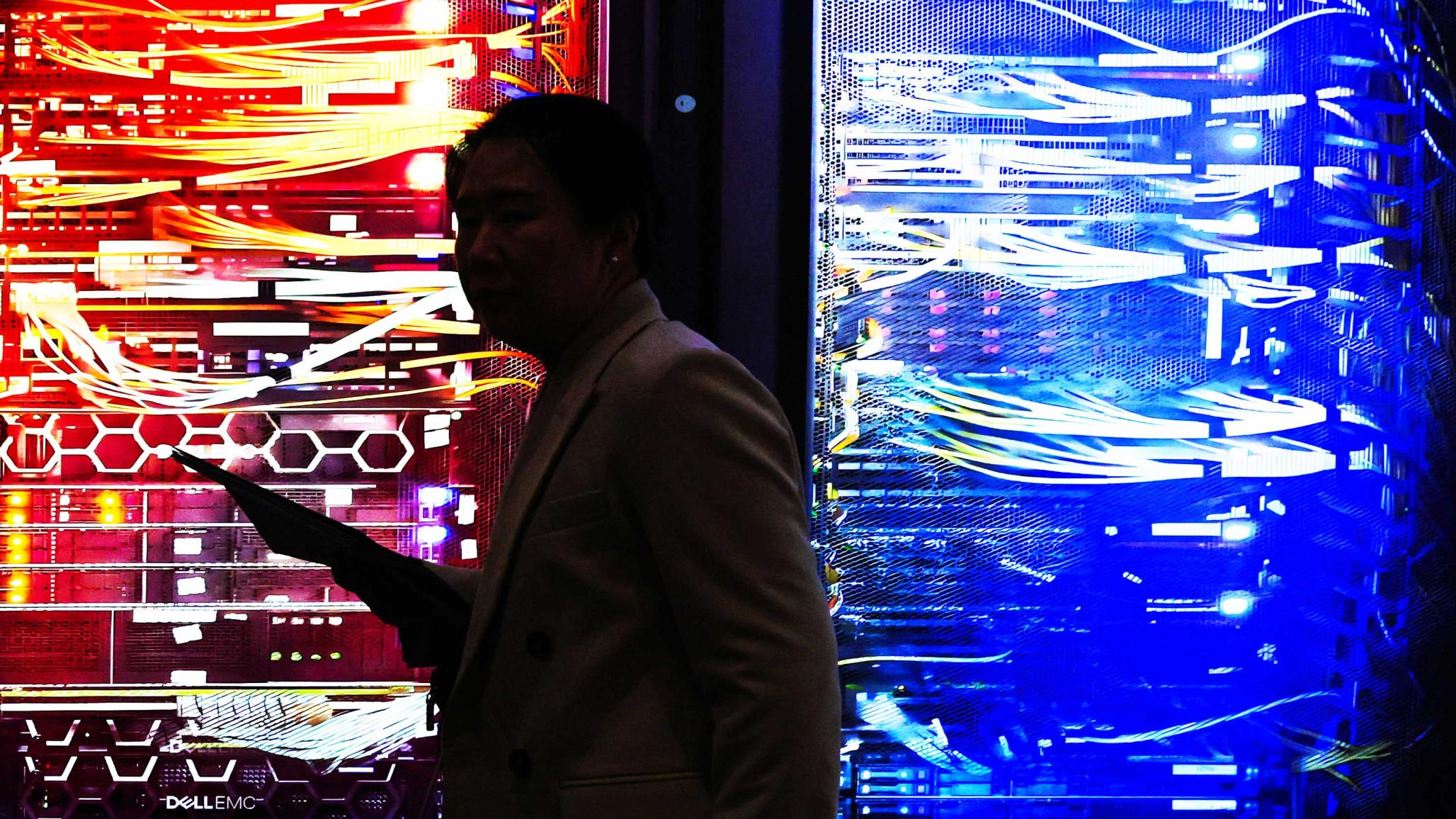 A person passes by a lit-up picture of a RAC AI server during the Mobile World Congress trade show in Barcelona, Spain. Photo taken on March 2, 2026. 