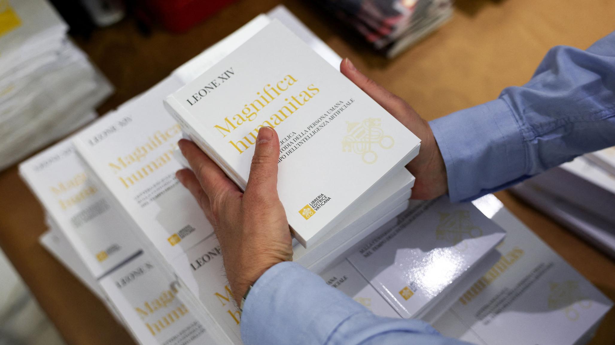 A worker places copies of Pope Leo XIV's first encyclical "Magnifica Humanitas" that focuses on the rise of AI. Photo taken at the Vatican on May 25, 2026. 