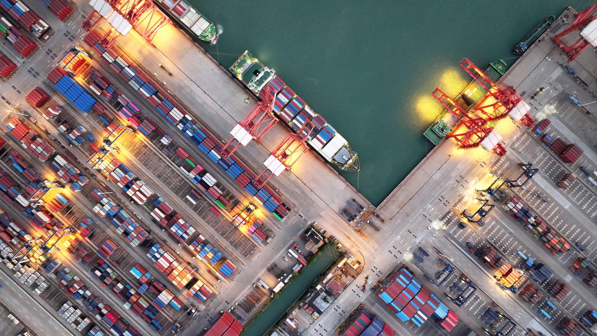 Aerial view of shipping containers stacked at a port in Asia. July 2025. 
