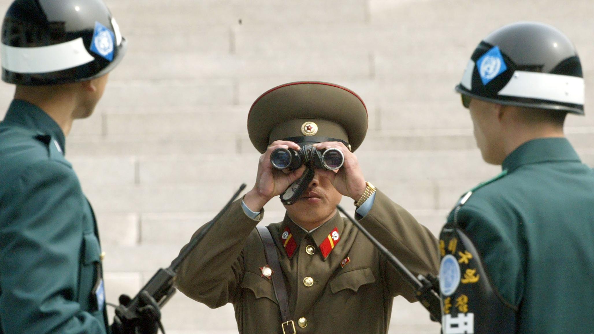 : A North Korean soldier looks at the south side through a pair of binoculars at the Panmunjom Truce village. 