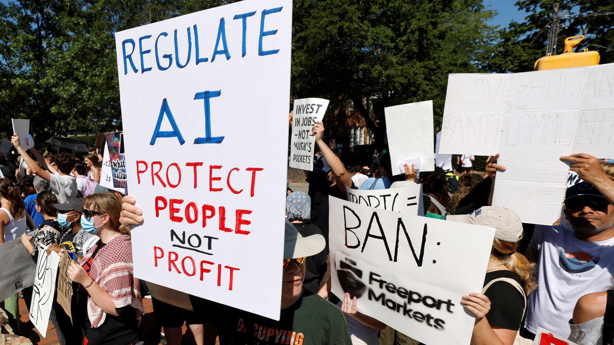 Demonstrators hold up signs calling for regulation of artificial intelligence during a protest in Chapel Hill. September 2026. 