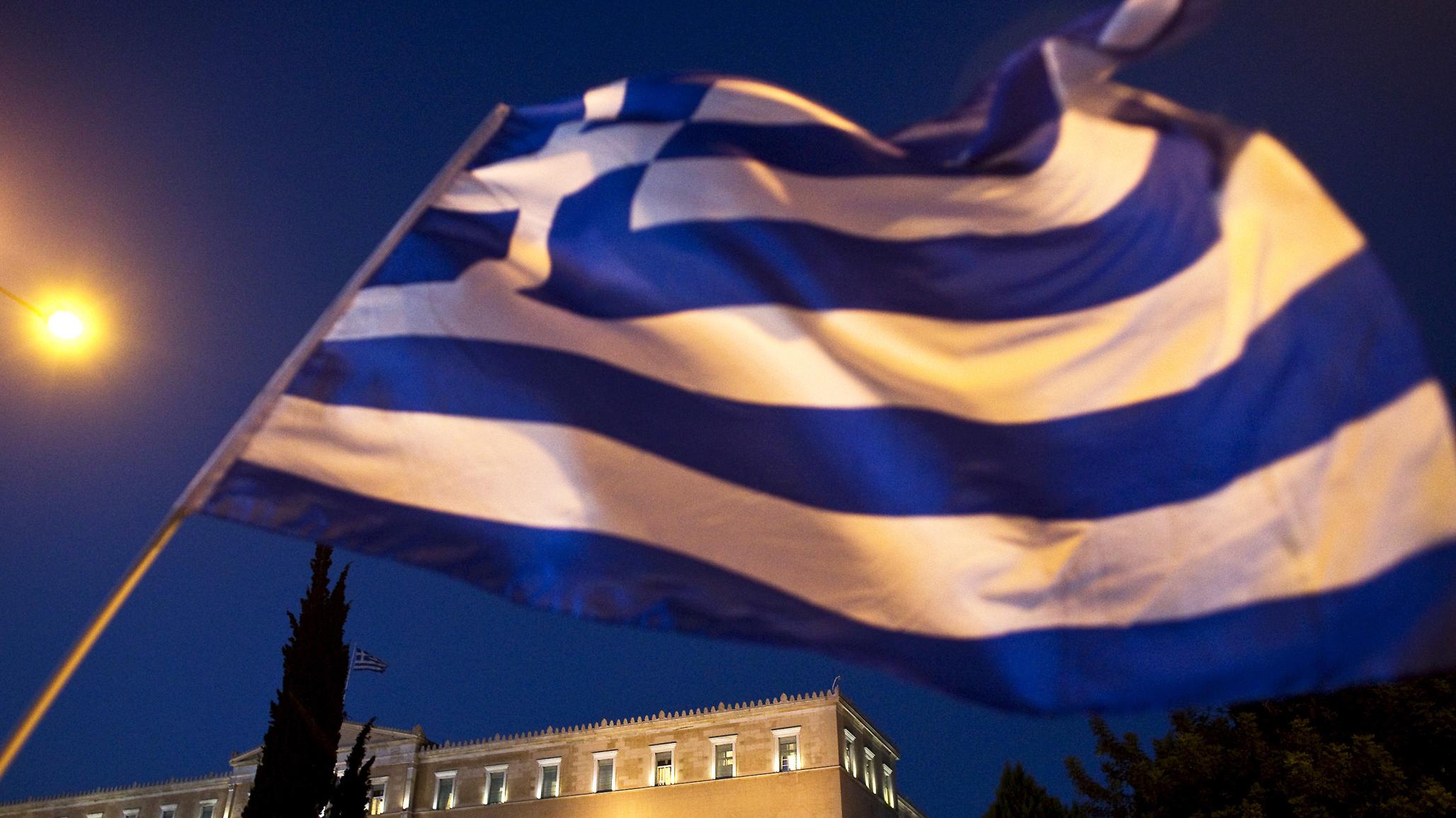 The Greek flag is seen at a rally in Athens, Greece. 