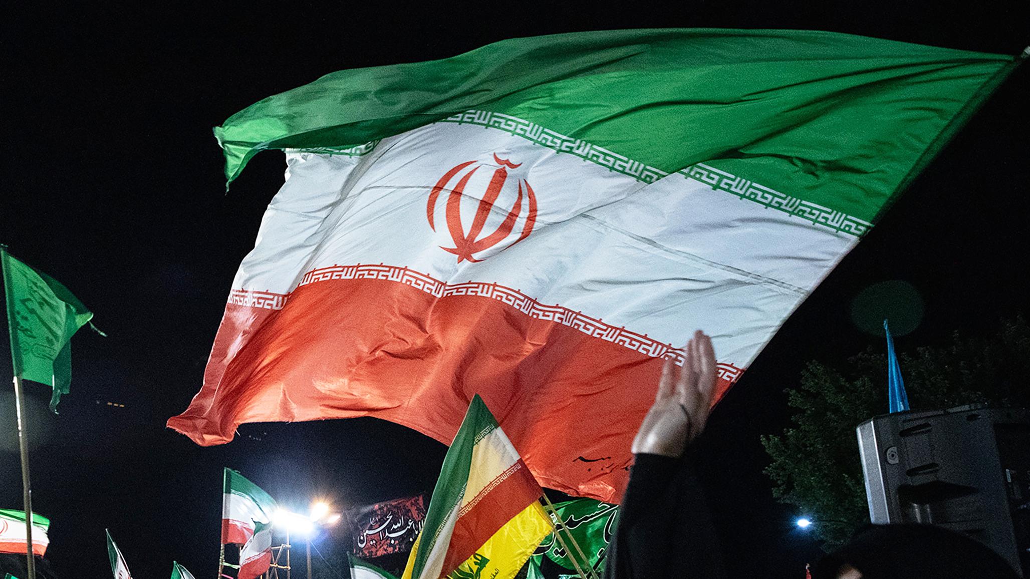 Iranians wave national flags during a rally in Tehran. 