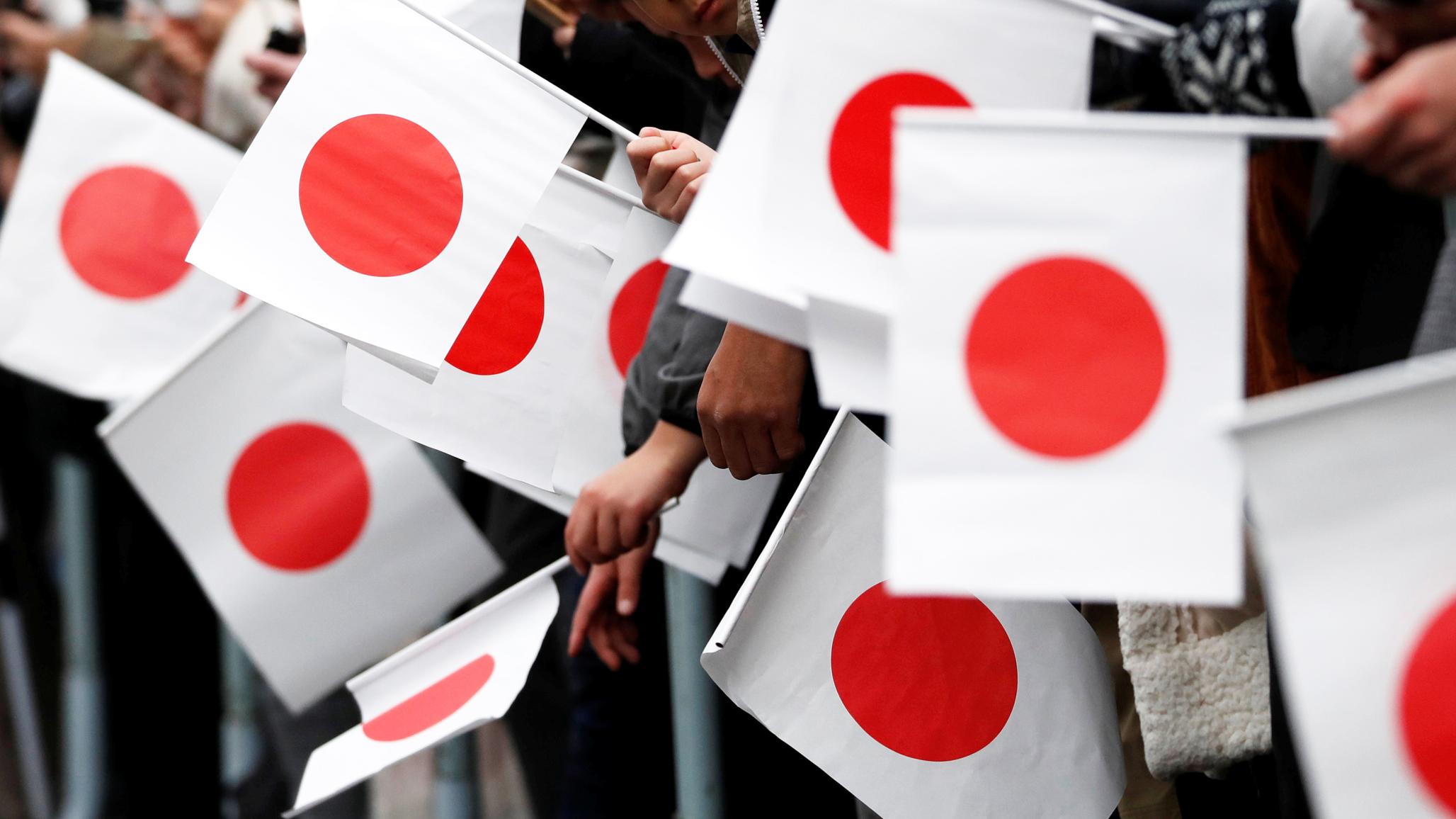 People hold the Japanese national flags during a parade in Tokyo, Japan. 