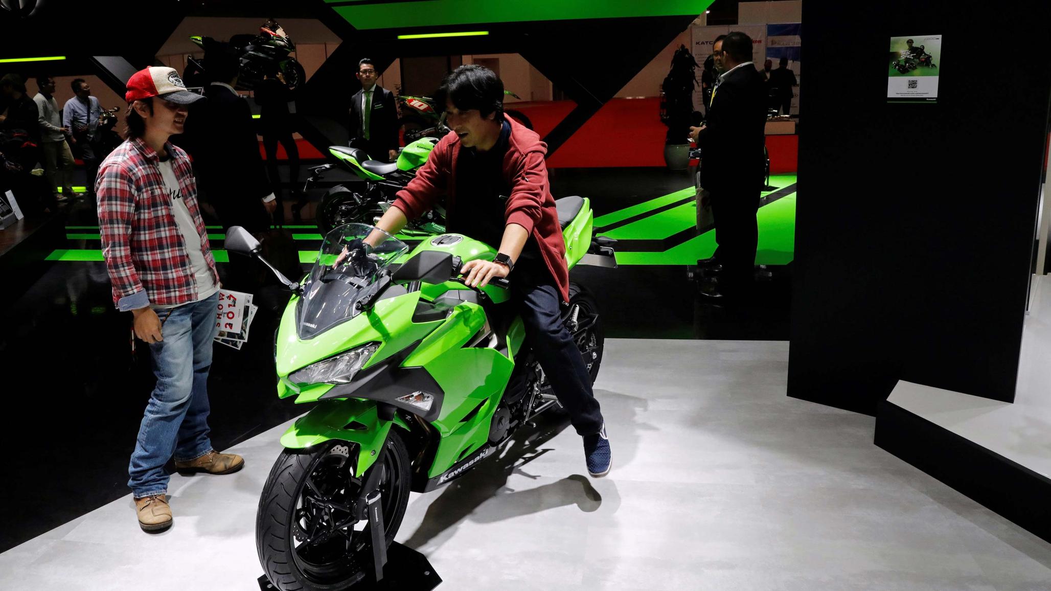 Visitors explore Kawasaki Motors' Ninja 250 model at the 45th Tokyo Motor Show in Tokyo, Japan October 27, 2017. 